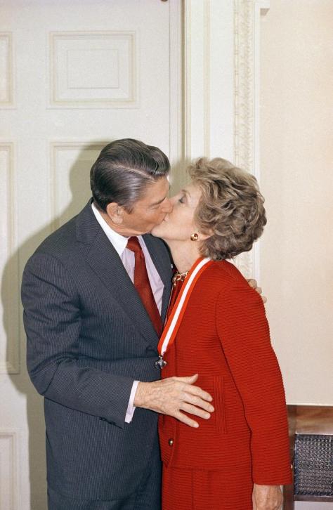 President Ronald Reagan and First Lady Nancy Reagan share a kiss {photo: news.wabe.org}
