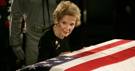 File photo of former U.S. first lady Nancy Reagan touching the casket of her husband former U.S. President Ronald Reagan as it lies in state on Captol Hill in Washington