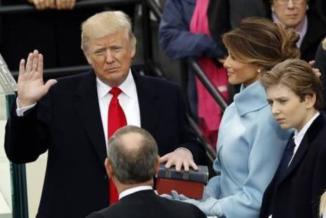 Donald Trump takes the oath of office with his wife Melania and son Barron at his side, during his inauguration at the U.S. Capitol in Washington